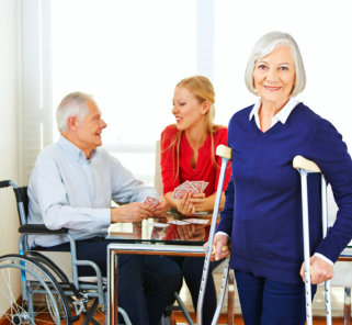 a senior woman on crutches with a senior man and a young woman playing cards in the background