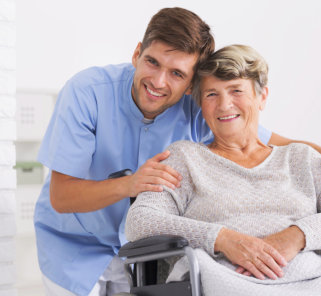 a male caregiver smiling with a senior woman