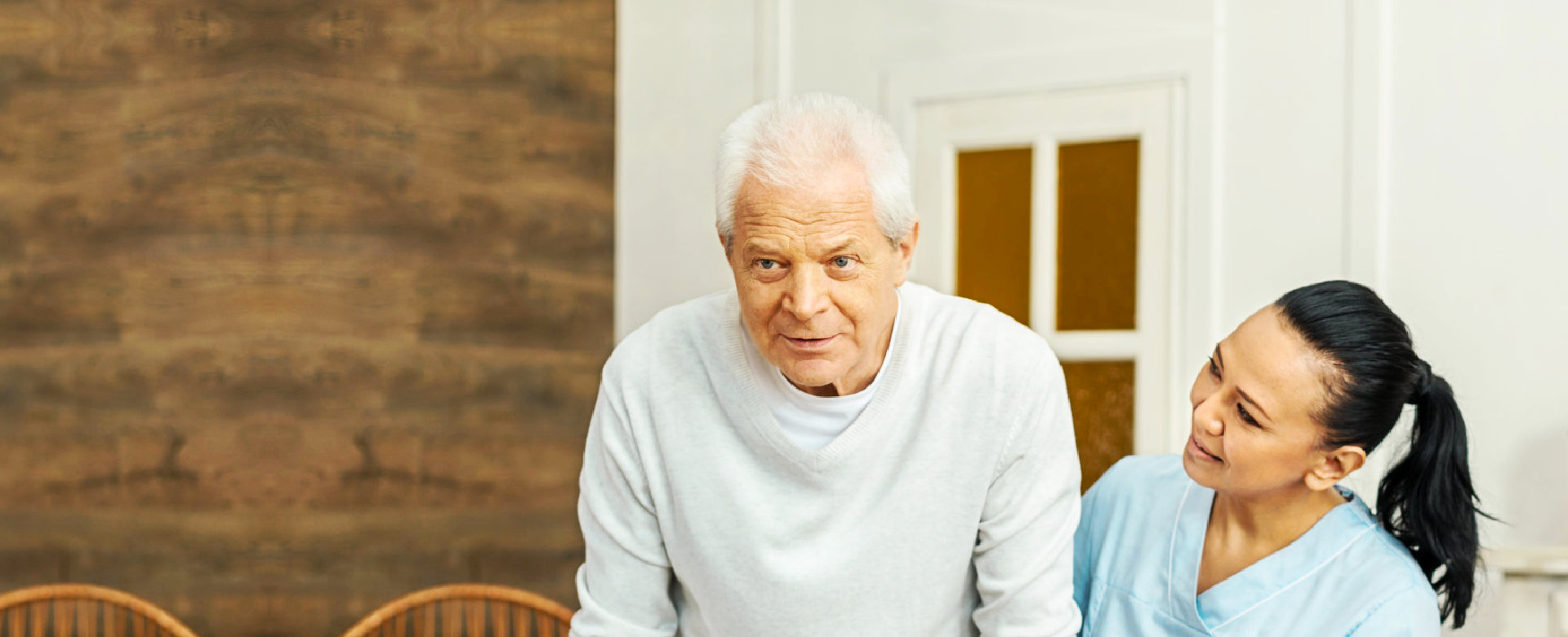 a young caregiver helping a senior man